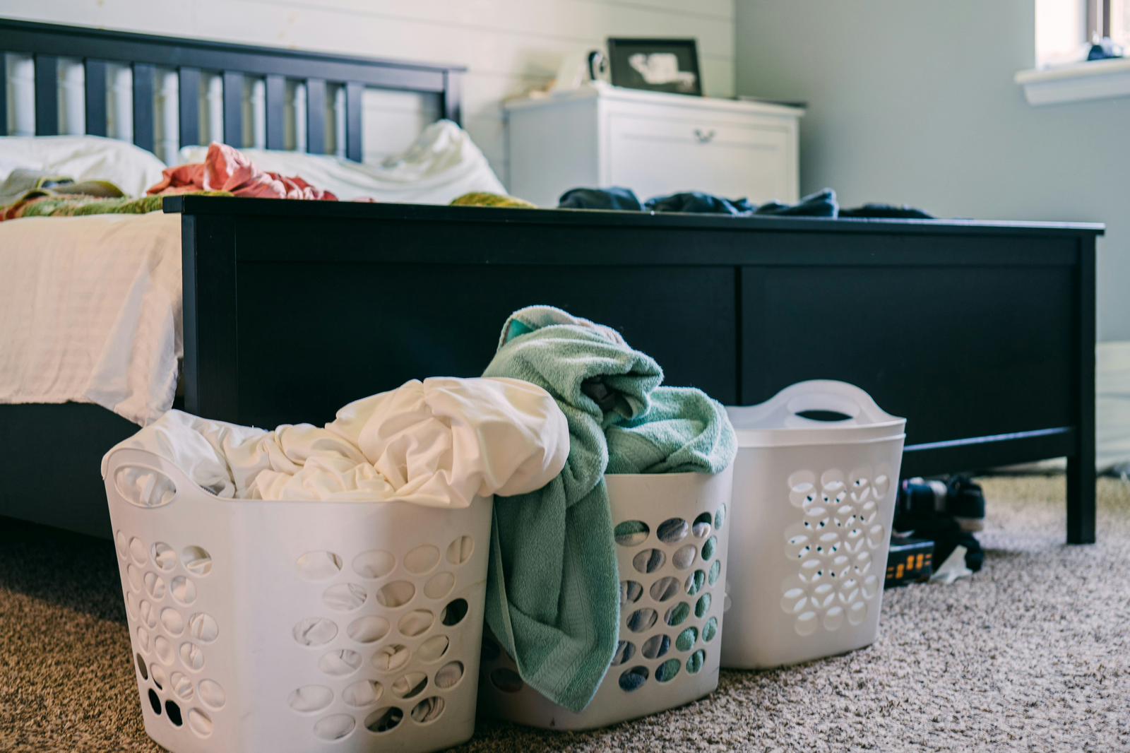 Messy bedroom with overflowing laundry baskets